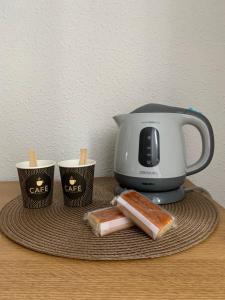 a toaster and two cups and some bread on a plate at Habitación privada para 2 personas a 10 min de la playa in Santander