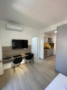 - un salon avec une télévision, une table et des chaises dans l'établissement Dora Family Apartments Budva, à Budva