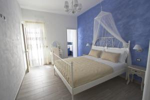 1 dormitorio con cama blanca y pared azul en Venustas, en Lampedusa