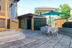 a patio with a table and a blue umbrella at 11 Venice Garden Private garden parking free in Marghera