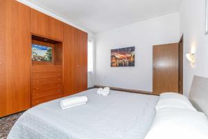 a bedroom with a large white bed and wooden cabinets at 11 Venice Garden Private garden parking free in Marghera