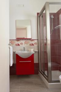 een badkamer met een rode wastafel en een douche bij Venustas in Lampedusa