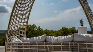 a wicker chair with white pillows on a patio at Can Paradís in San Antonio