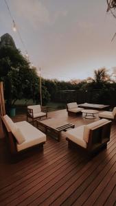 una terraza de madera con tumbonas y mesas. en Casa Pé na Areia Noronha en Fernando de Noronha