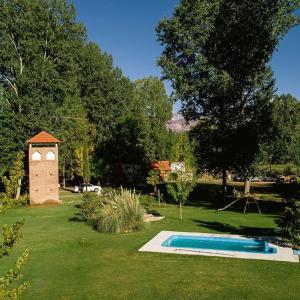 a swimming pool in a yard with a bird house at Cabaña en Alta Montaña - Complejo Cabañas del Pastizal - USPALLATA, MENDOZA in Uspallata