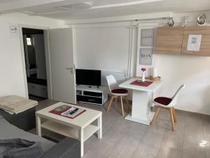 una pequeña sala de estar con mesa y sillas. en Ferienwohnung Bella, en Hühnerfeld