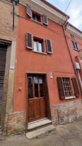MombaruzzoにあるCasa Viscontiの木製のドアと窓のあるオレンジ色の建物
