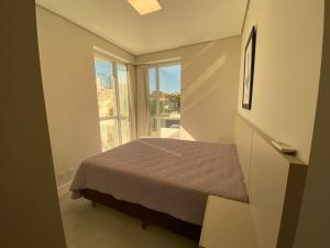 Habitación pequeña con cama y ventana en Apartamento amplo bem equipado, en João Neiva