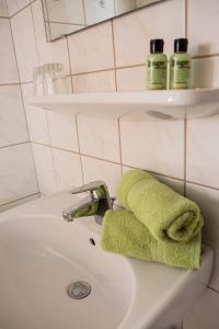 a bathroom sink with a green towel on it at Lehenriedl Appartements in Wagrain