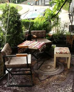 a porch with two chairs and a table and a swing at CASA Sarajevo Apartment in Sarajevo