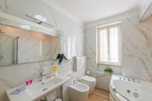 ein weißes Bad mit einem Waschbecken und einem WC in der Unterkunft Il canto delle Sirene in Anzio