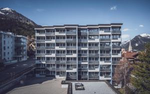 ein großes Apartmenthaus vor einem Berg in der Unterkunft Club Hotel Davos by Mountain Hotels in Davos