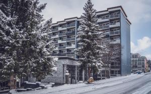 un gran edificio con árboles nevados delante de él en Club Hotel rooms only - by Mountain Hotels, en Davos