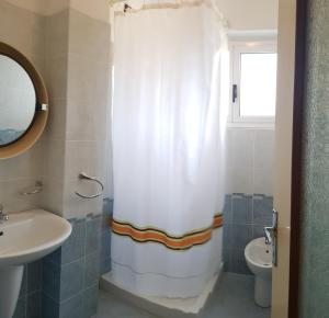 ein Bad mit einem Duschvorhang und einem Waschbecken in der Unterkunft Casa Liver Pieve in Tremosine sul Garda