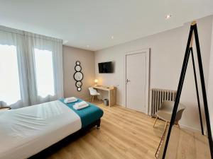 a bedroom with a bed and a desk and a chair at Le Five Tellier - Blossom in Reims