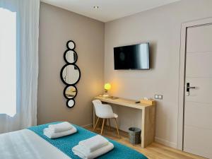 Dormitorio con cama, escritorio y TV en Le Five Tellier - Blossom, en Reims