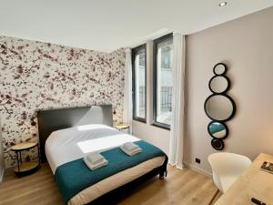 a bedroom with a bed with a floral wall at Le Five Tellier - Blossom in Reims