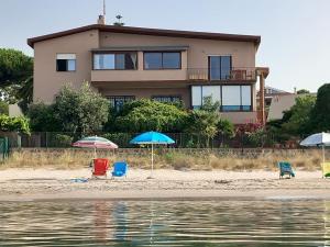 a house on the beach with chairs and umbrellas at Bed and Breakfast Onde Beach Poetto in Su Forti