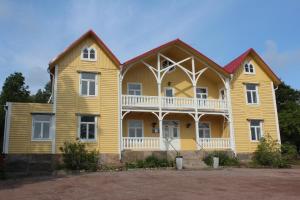 a large yellow house with a large balcony at Alebo Pensionat in Unnaryd