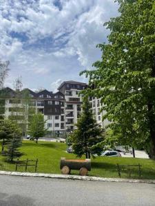 a park with a bench in front of a building at Arboro Borovets Gardens E43 in Borovets