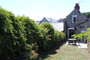 a house with a hedge in front of a yard at Town centre apartment with parking in Padstow