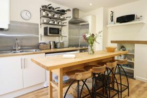 a kitchen with a wooden table with stools at Town centre apartment with parking in Padstow