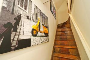 a yellow scooter hanging on a wall next to a staircase at Town centre apartment with parking in Padstow