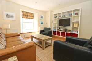 a living room with a couch and a tv at Town centre apartment with parking in Padstow