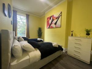 a bedroom with a bed with pillows and a dresser at LUXURY Holiday Home Elizabeth Line in London