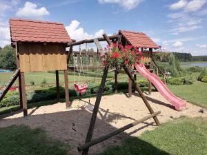 un parque infantil con tobogán y columpio en Domek Czerwony Kapturek, en Płocice