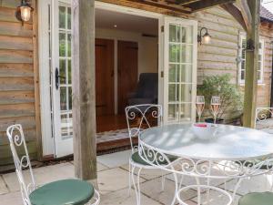 a patio with a table and chairs on a porch at Spindlewood Cottage in Cranbrook