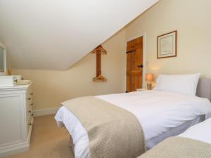 a bedroom with two beds and a dresser at Spindlewood Cottage in Cranbrook