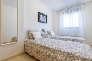a bedroom with two beds and a window at A&N La Vega 11 in Torre del Mar +42 photos