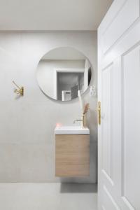 a bathroom with a sink and a mirror at Elite Apartments Sandy in Gdańsk +10 photos