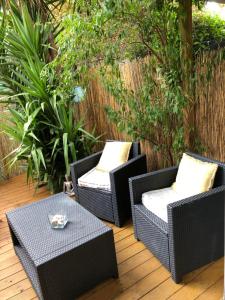 2 sedie in vimini e un tavolo su un patio di Agréable T2 traversant RDC avec terrasse + balcon+ Parking 2 places a Montpellier