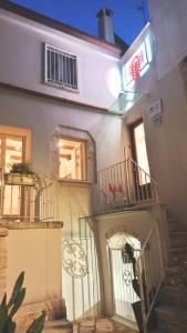 a white building with stairs and a balcony at Antiche Mura Apartments"Cielo di Puglia" -2 matrimoniali, cucina,letto singolo e terrazzo in Turi