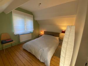 a bedroom with a white bed and a window at Les Nids in Spa