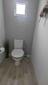 La salle de bains est pourvue de toilettes et d'une fenêtre. dans l'établissement Andernos-Maison de centre-ville avec jardin, à Andernos-les-Bains