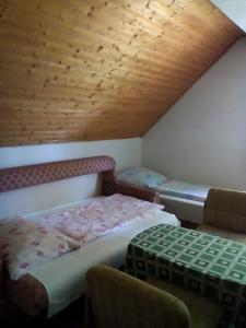 um quarto no sótão com uma cama e 2 cadeiras em F 106 Vendégház em Fertőhomok