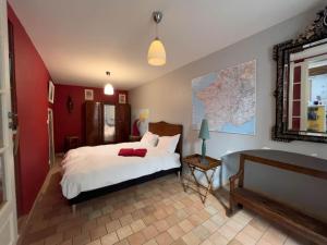 a bedroom with a white bed and a red wall at Maison traditionnelle centre Montsoreau in Montsoreau