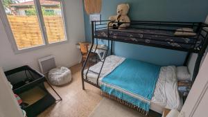 - une chambre avec des lits superposés avec un ours en peluche au-dessus dans l'établissement Andernos-Maison de centre-ville avec jardin, à Andernos-les-Bains