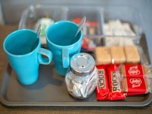 a tray with two blue coffee mugs and some food at The Llandudno Hotel in Llandudno