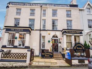 a large white building with the front entrance to the laird hamel hotelleep at The Llandudno Hotel in Llandudno