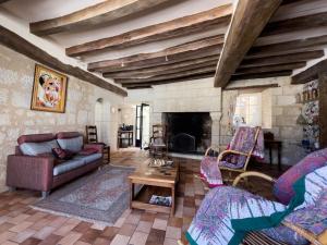 ein Wohnzimmer mit einem Sofa und einem Kamin in der Unterkunft Maison traditionnelle centre Montsoreau in Montsoreau