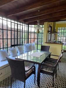 uma sala de jantar com uma mesa de vidro e cadeiras em Villa Tamen - Colonia em Colônia do Sacramento
