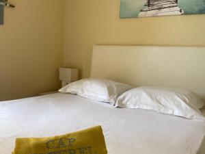 a bed with white pillows and a sign on it at Appartement Saint-Raphaël, 1 pièce, 4 personnes - FR-1-504-567 in Saint-Raphaël