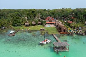 an aerial view of a house with a boat in the water at Hotel CasaBakal - A pie de Laguna - Bacalar in Bacalar