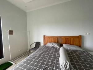 een slaapkamer met een bed en een stoel bij Cozy 3BR House - 8min From City Centre by Sakura 