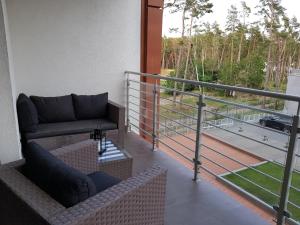 a balcony with a couch and a balcony railing at Apartament PORTA MARE 115 Wes Quality Suite in Dziwnówek