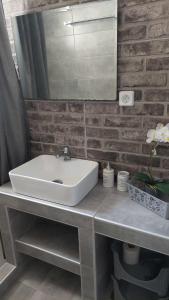 baño con lavabo blanco y pared de ladrillo en Anezinas place, en Perissa